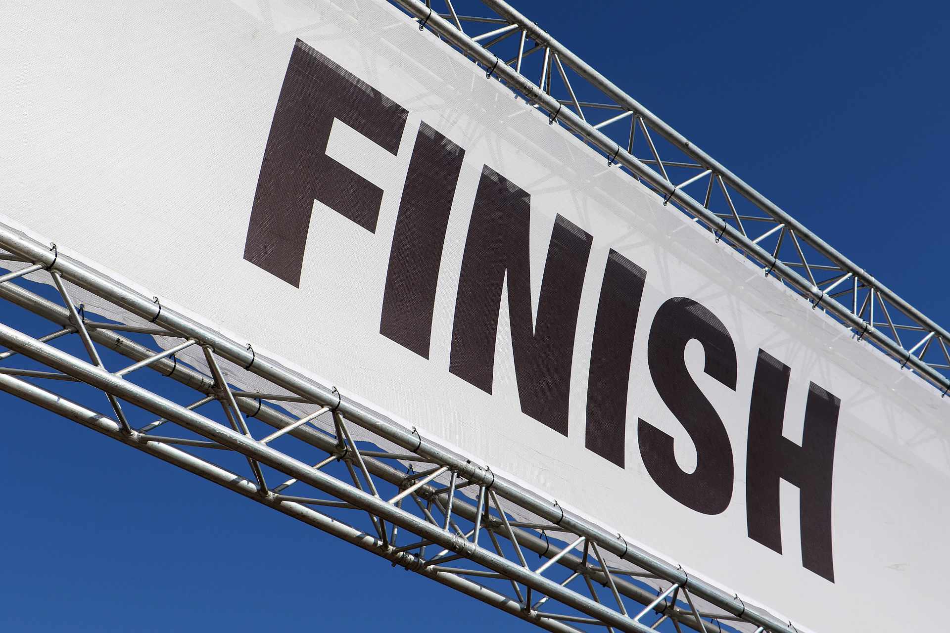 Finish line banner across a clear blue sky